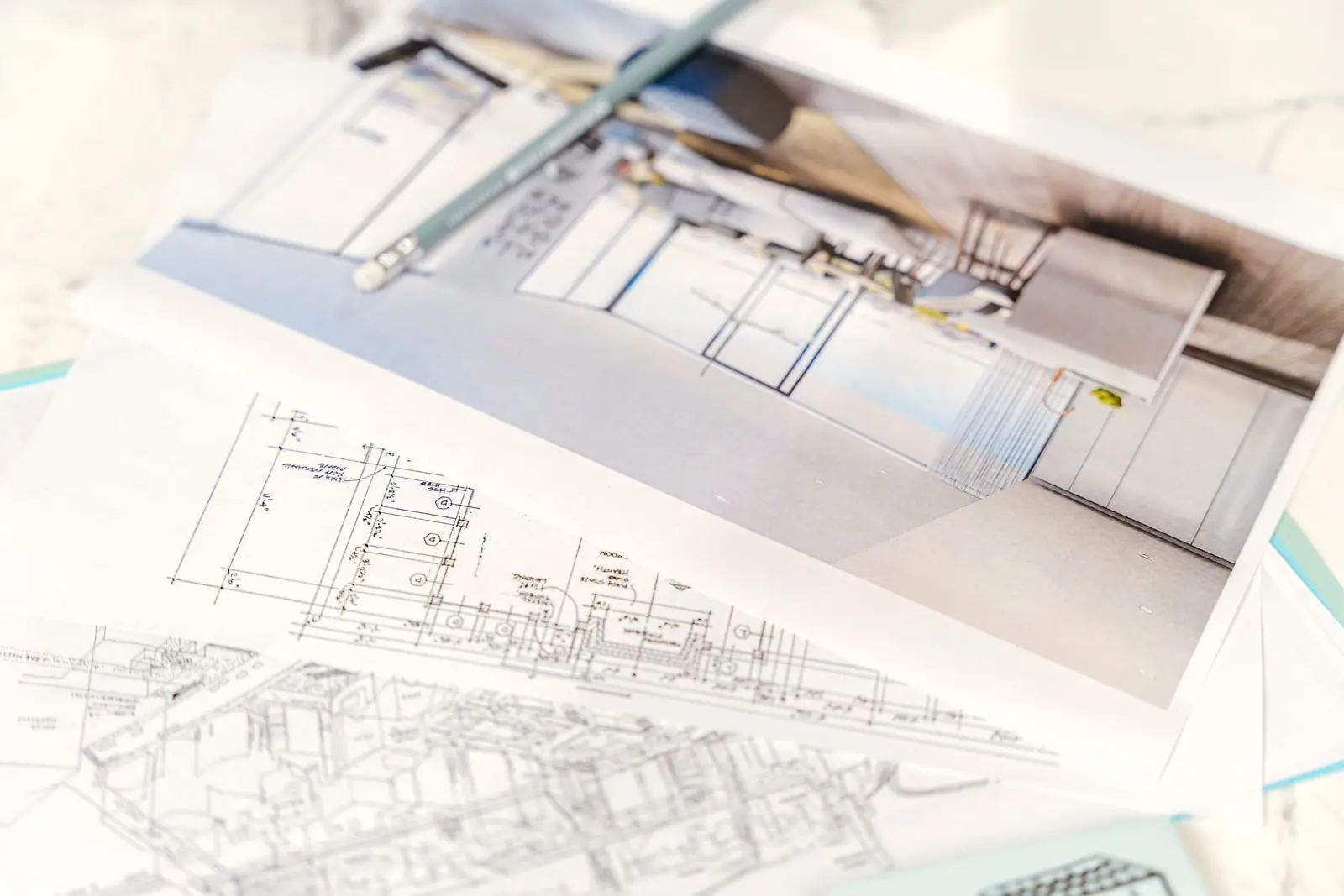 Architectural floor plans and sketches spread across a desk